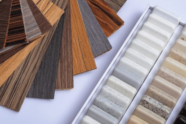 Wood veneer and stone worktop material samples laid out for a bespoke kitchen design consultation, Ashley Jay Kitchens